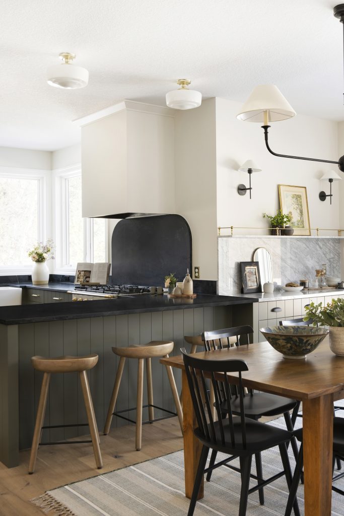 Two tone kitchen cabinetry with natural soapstone countertops, La Carnue range, brass details.