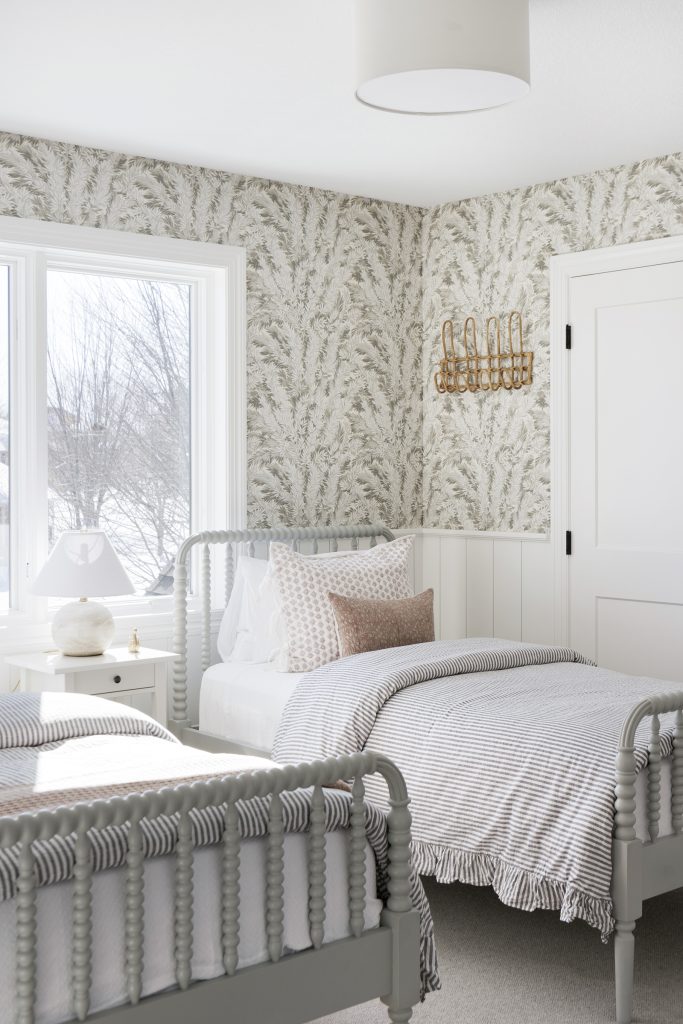 Guest suite floral wallpaper, twin beds, natural light, drum shade light fixture.