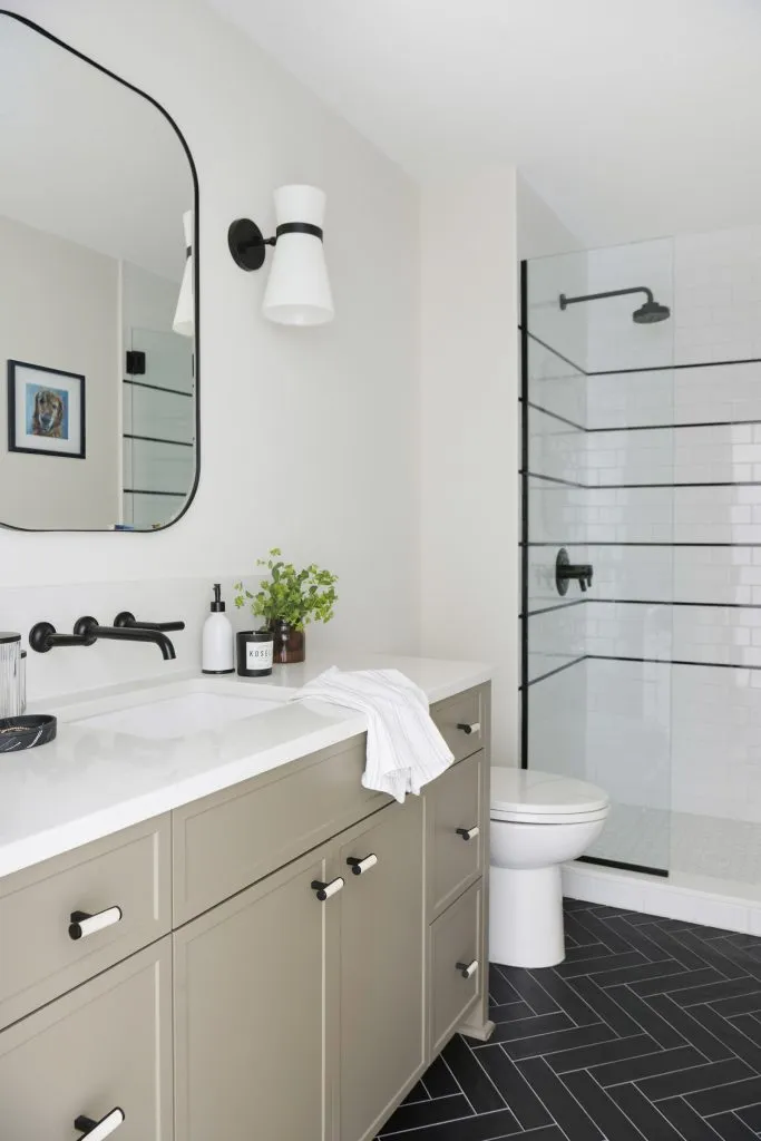 Hall bath, with painted olive tone bathroom vanity, black and white tiles.