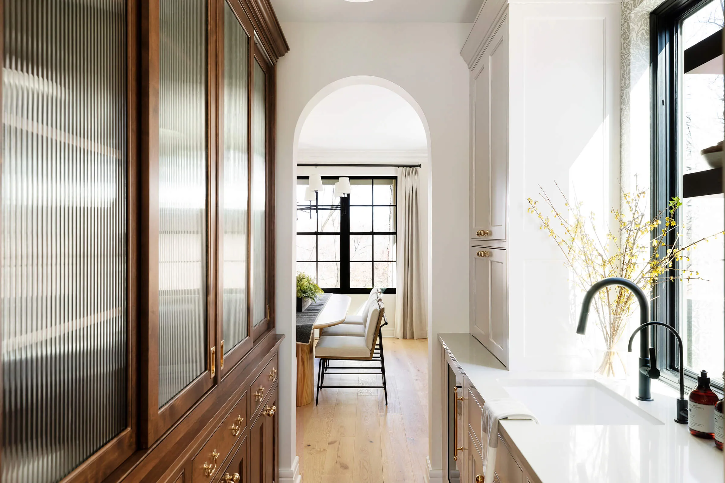 Modern Tudor with black casement and double Hund windows, two tone custom cabinetry, black faucet.