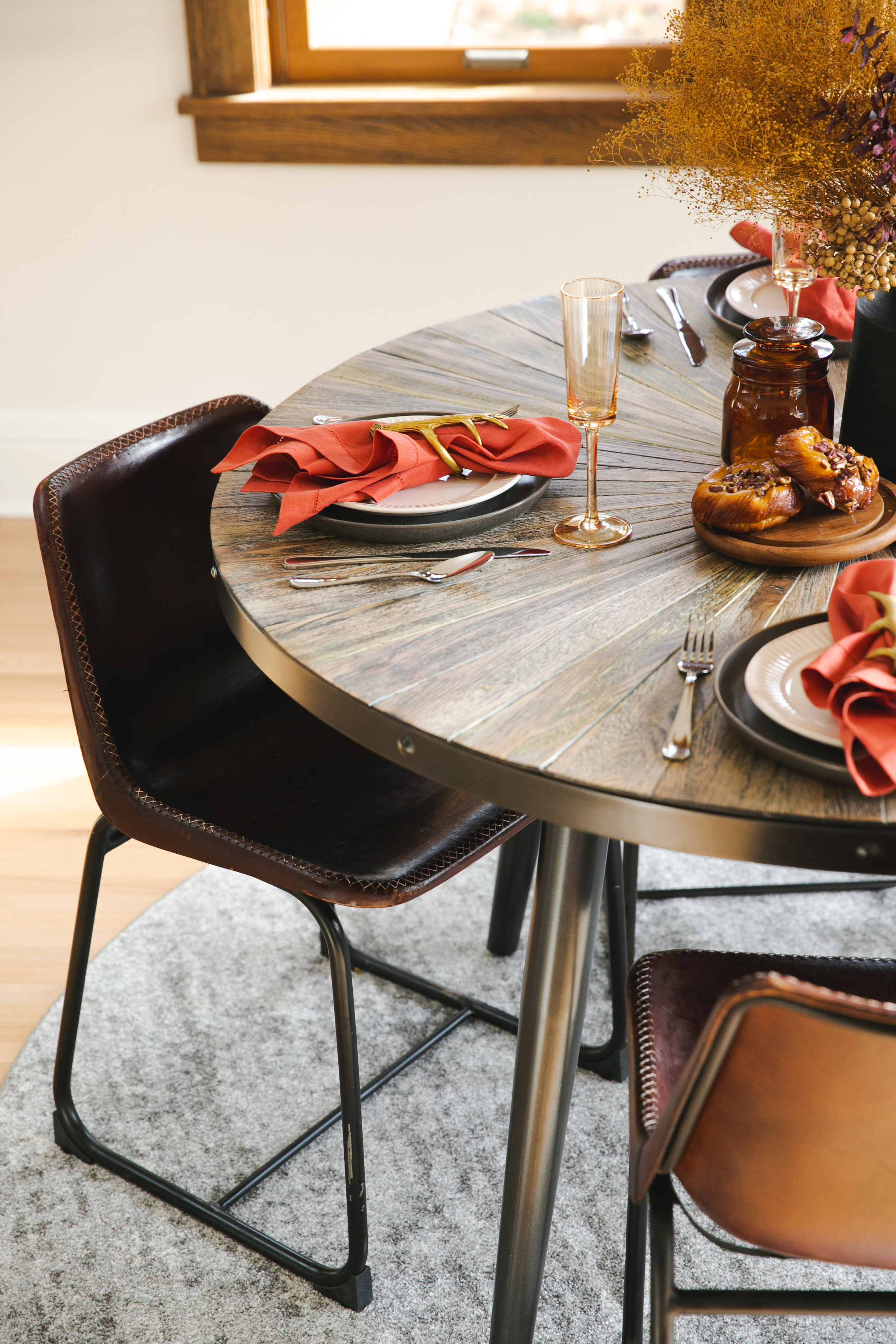 Dried floral with black wood vase, contrasting red holiday decor for table setting.