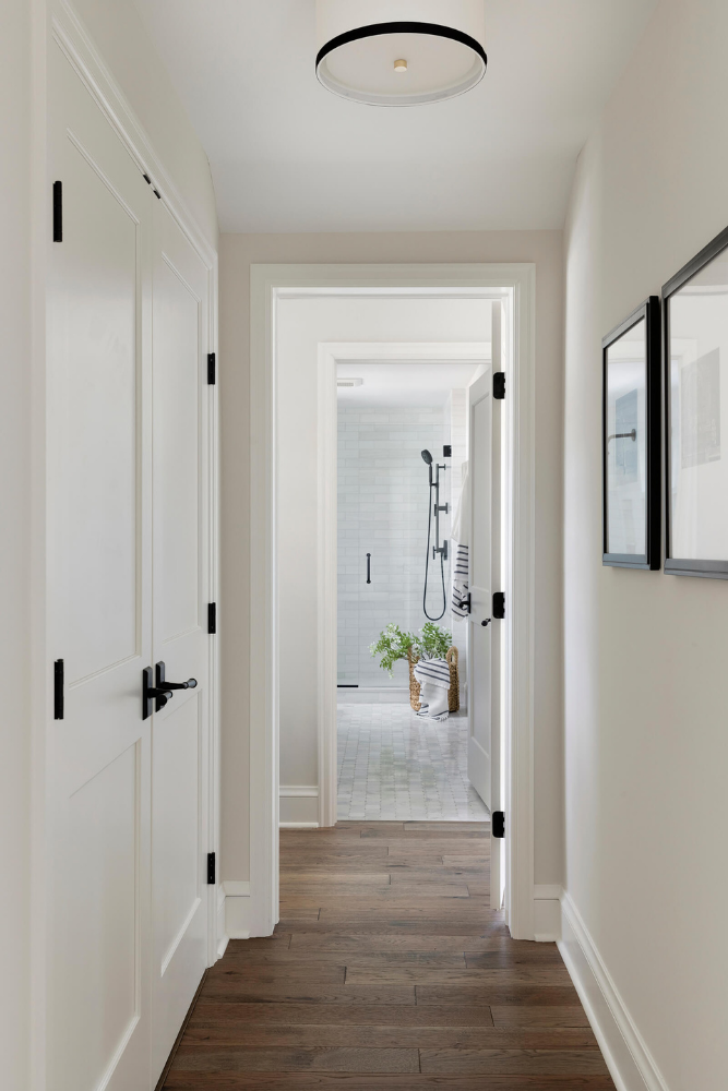 Hallway with white walls and black hardware.