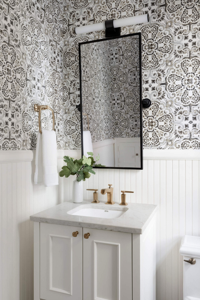 Powder room with black and white metals, beadboard wall treatment, and traditional wallpaper.