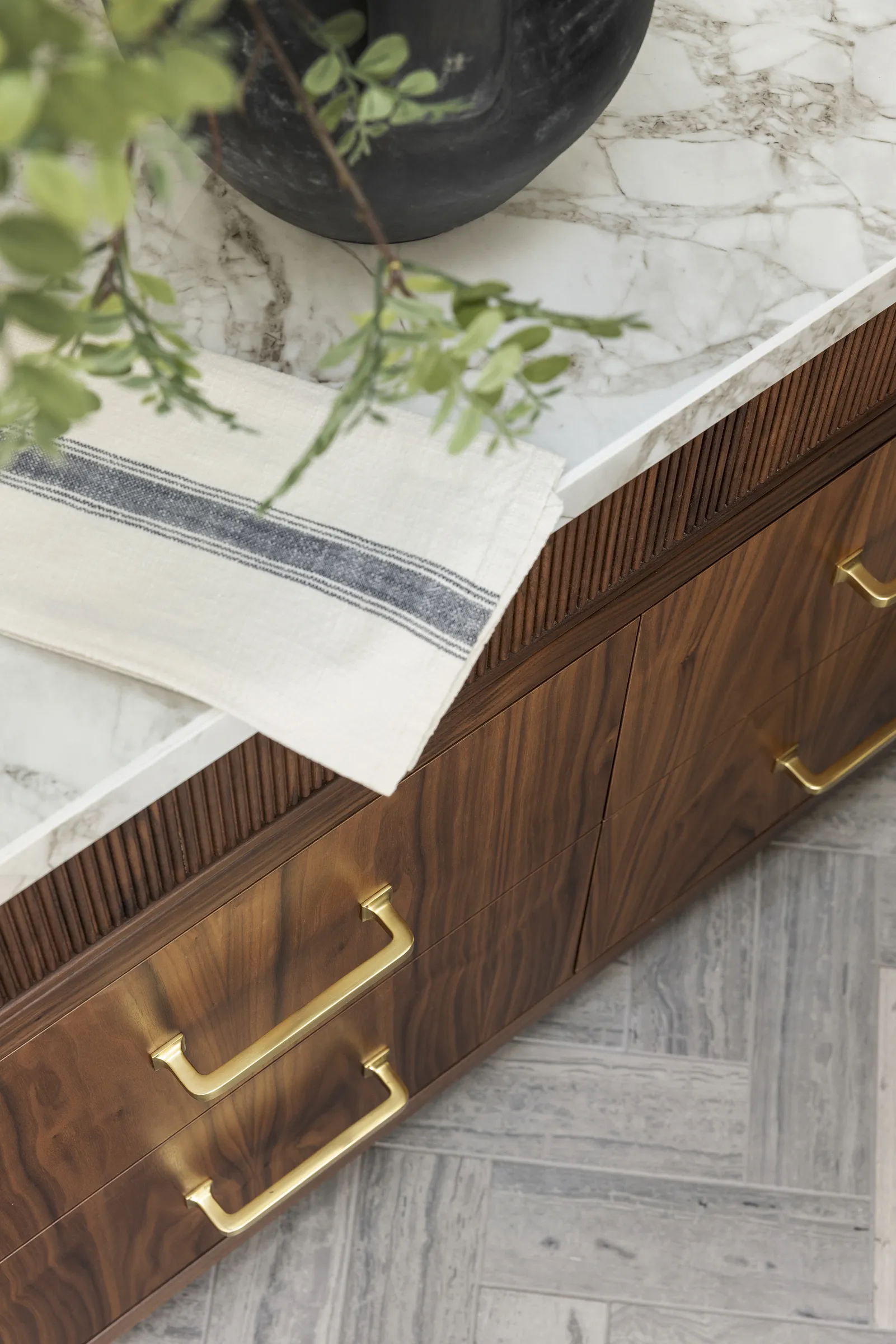 Custom walnut bathroom vanity, reeded details, limestone tile flooring and polished brass accents.