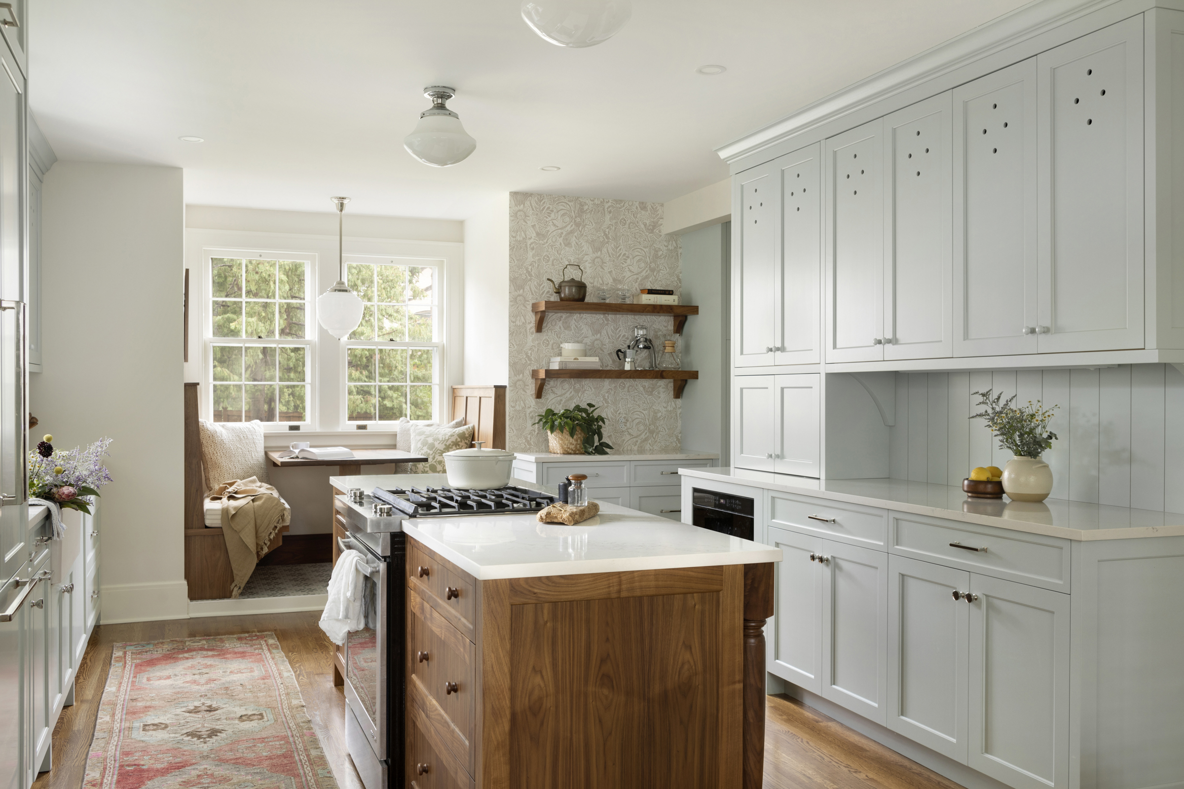 Custom blue kitchen cabinetry with walnut island quartz countertops, vintage lighting, wallpaper and open shelf details