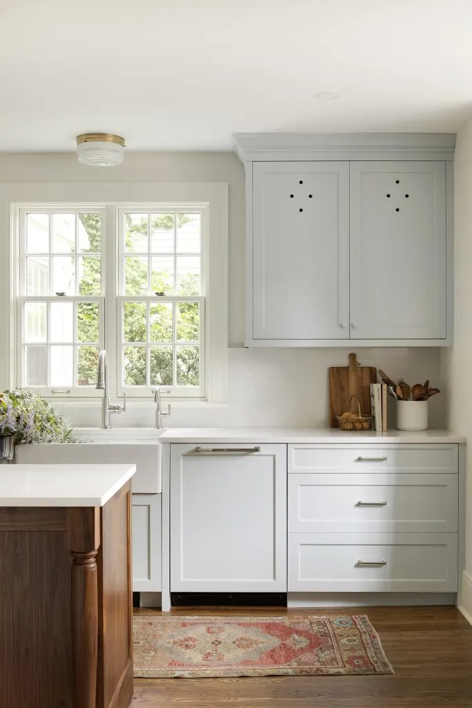 Custom blue kitchen cabinetry with walnut island quartz countertops, vintage lighting, wallpaper and open shelf details