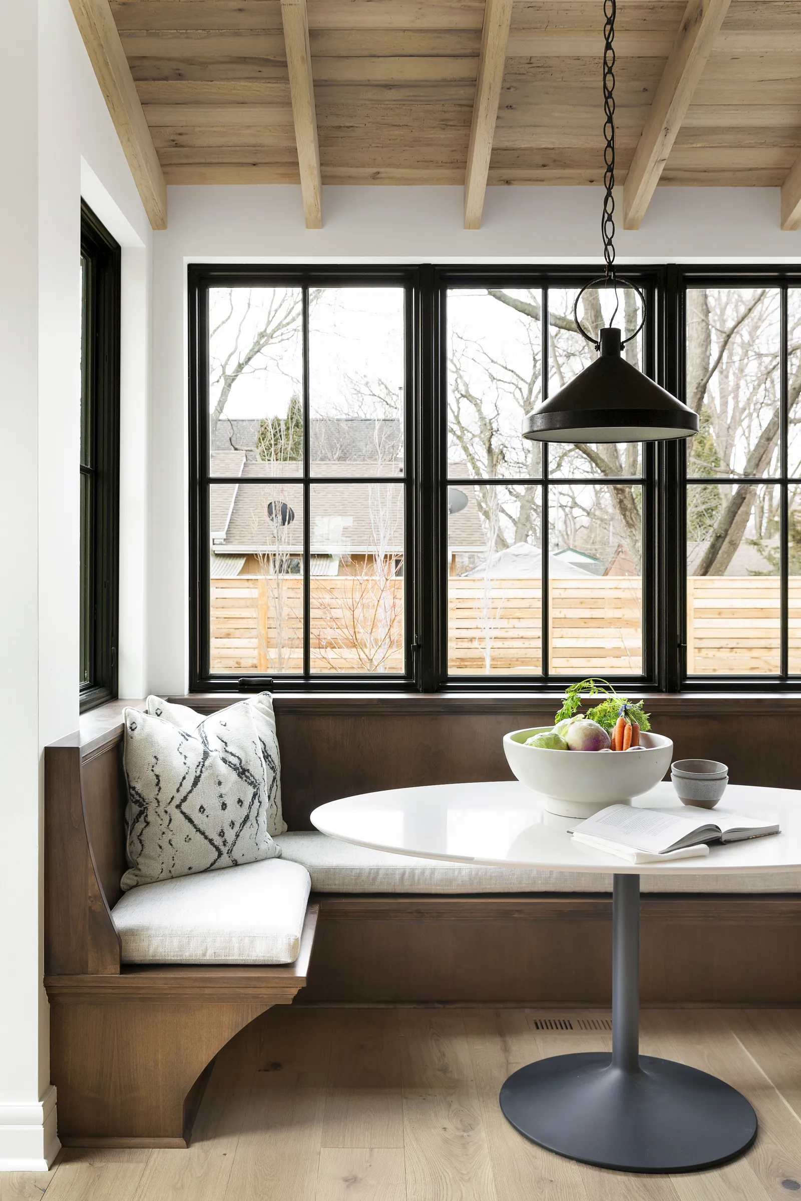 Breakfast nook with black windows, and alder wood built in bench.