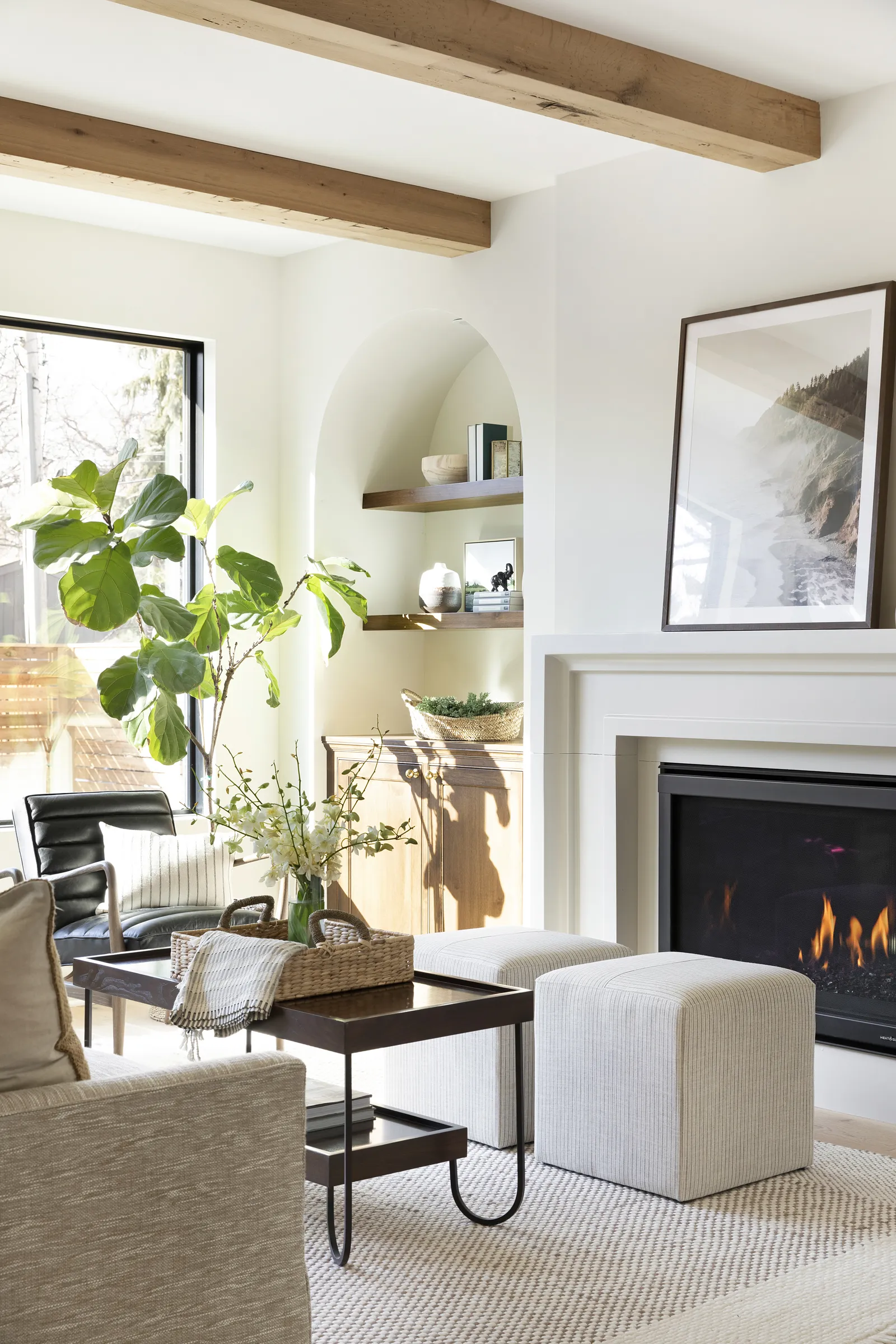 Cast stone fireplace in modern tudor home with reclaimed wood ceiling beams.