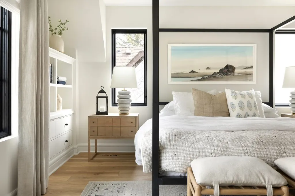 Modern Traditional bedroom with watercolor painting, white oak flooring, black windows and metal bed frame.