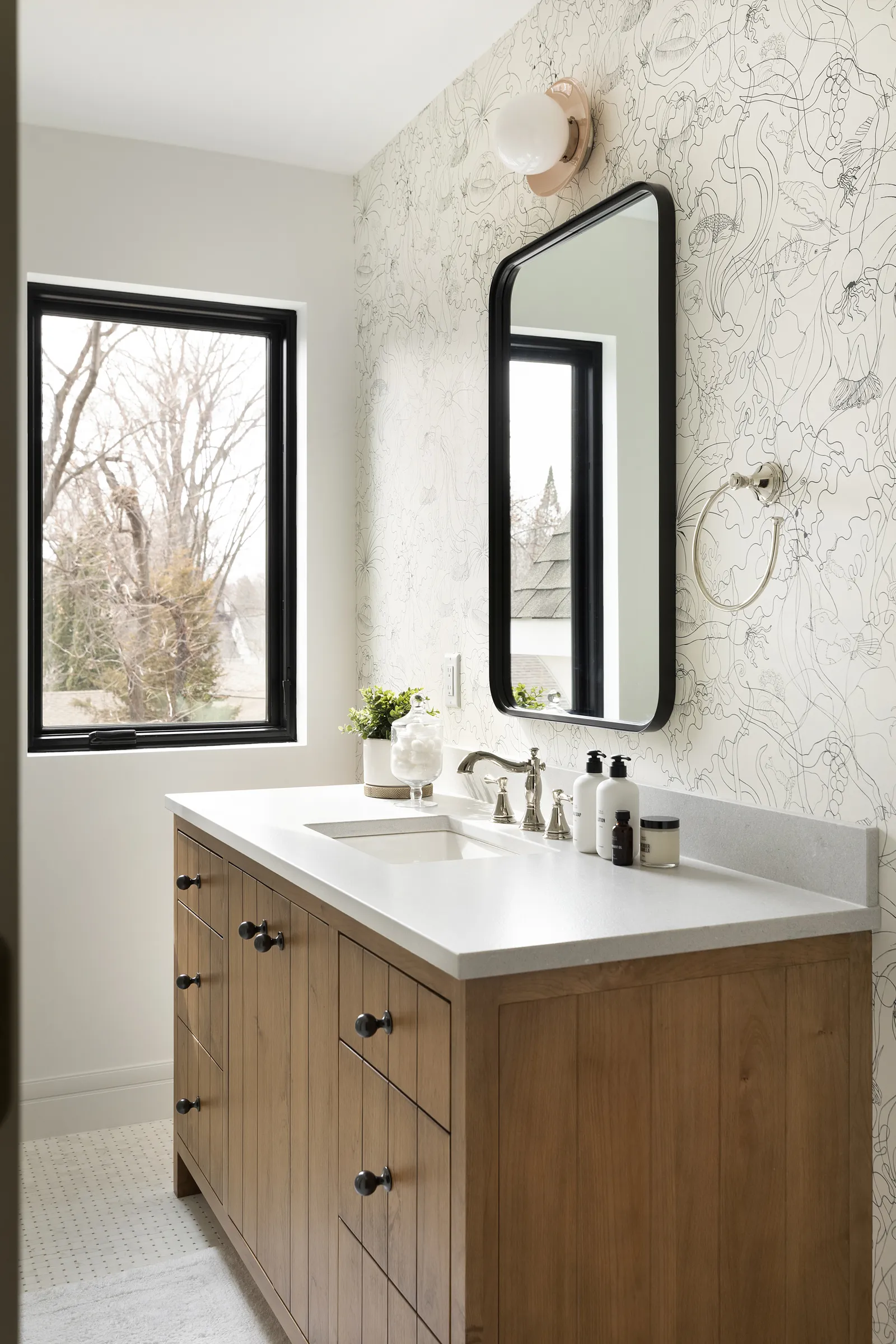 Custom Murphy vanity in alder wood with whimsical wallpaper and polished nickel finishes