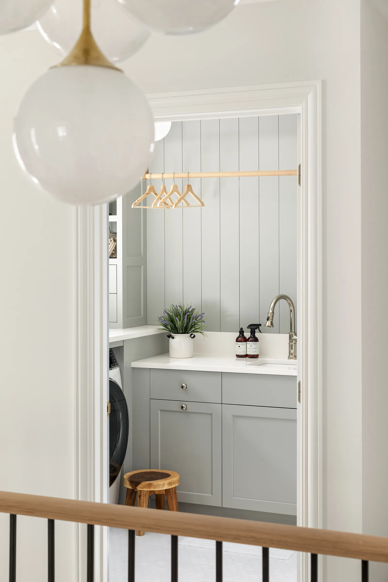 Monochromatic blue laundry room, white hex floor tile, polished nickel fixtures.