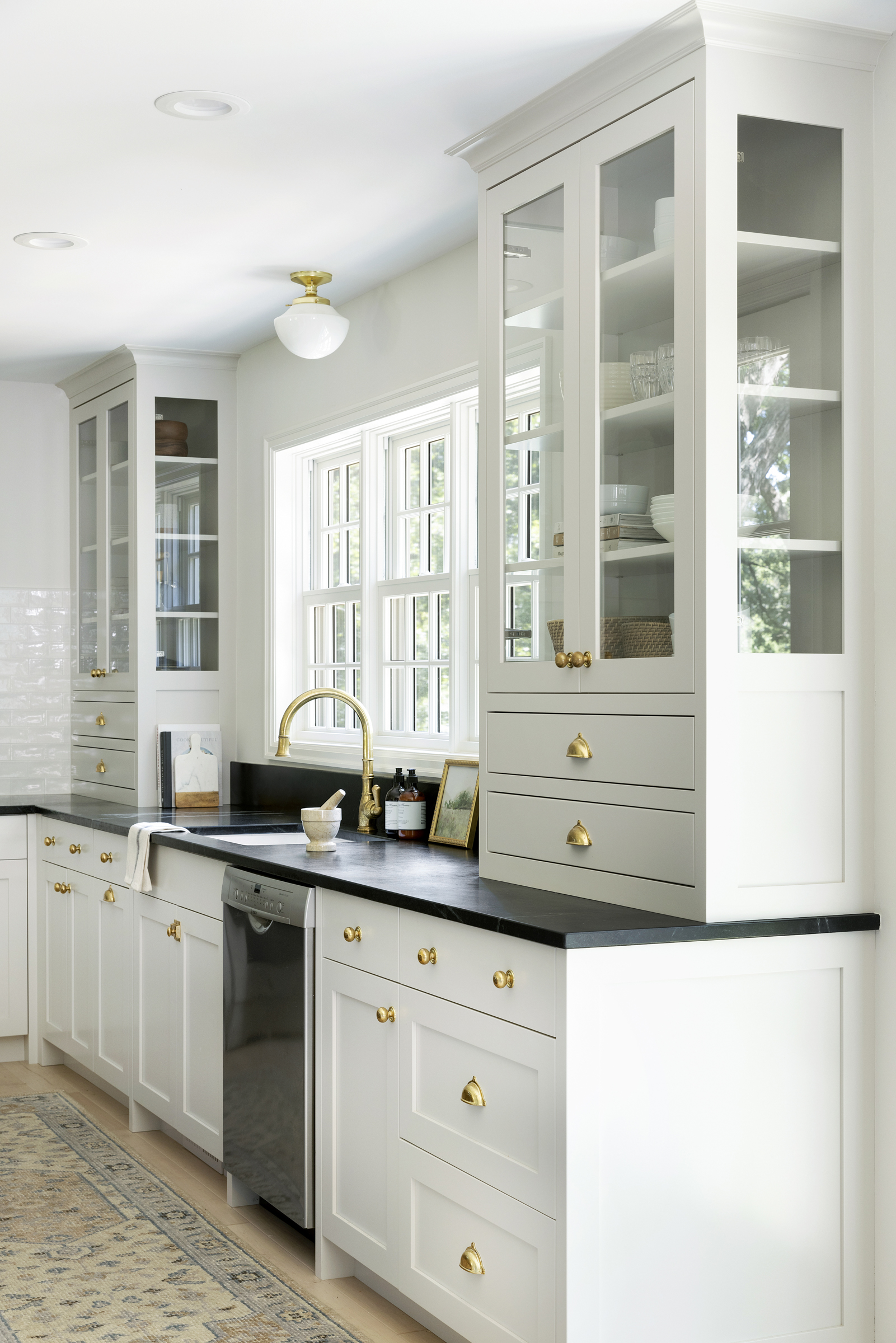 Twin Cities kitchen renovation with white perimeter cabinets, soapstone countertop, and brass hardware.