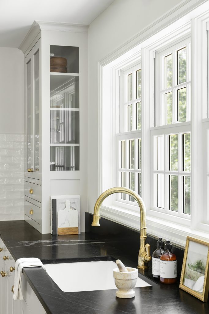 Soapstone countertops, unlacuered brass kitchen faucet.