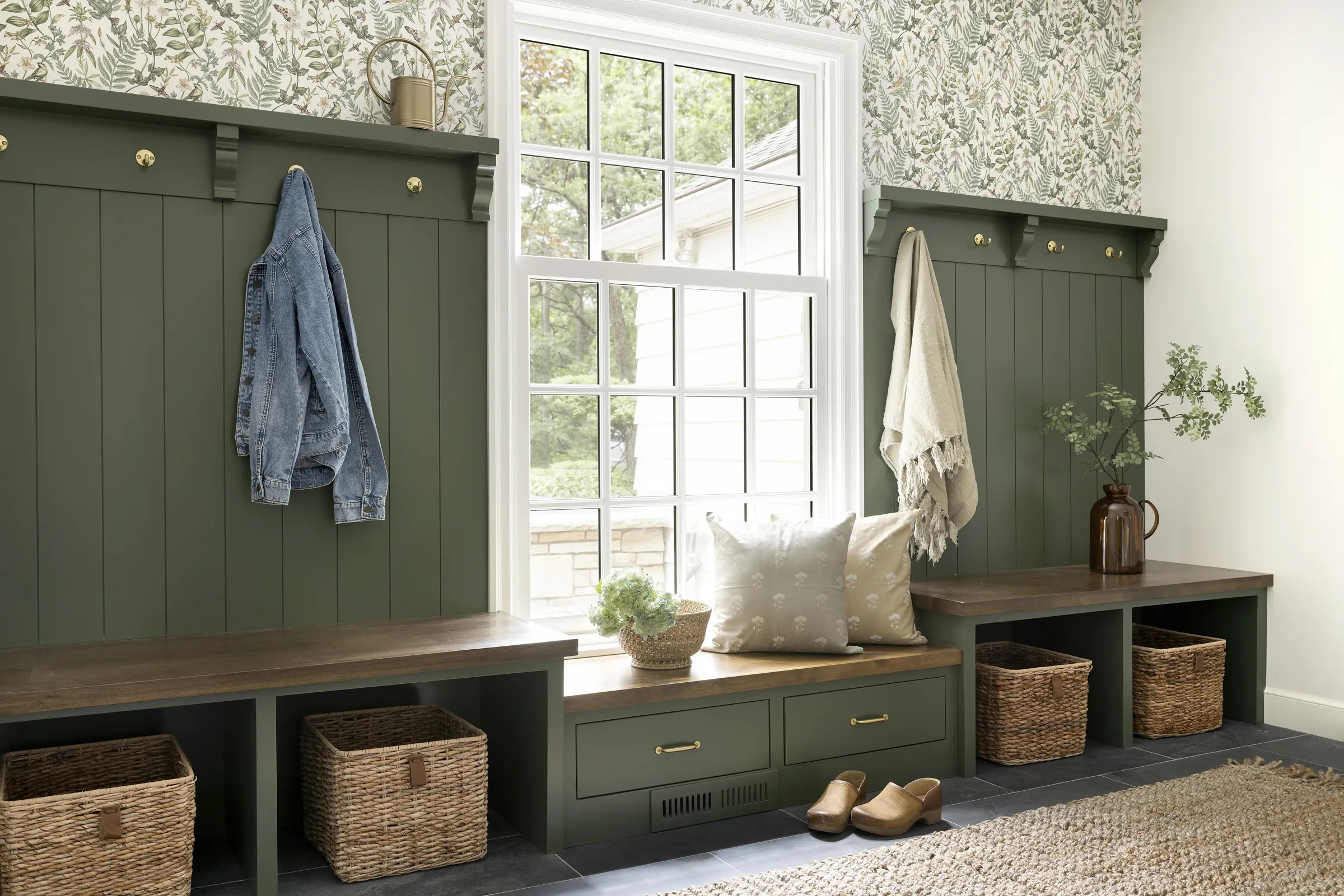 Twin Cities mudroom renovation with green paneling, botanical wallpaper, and window seat.