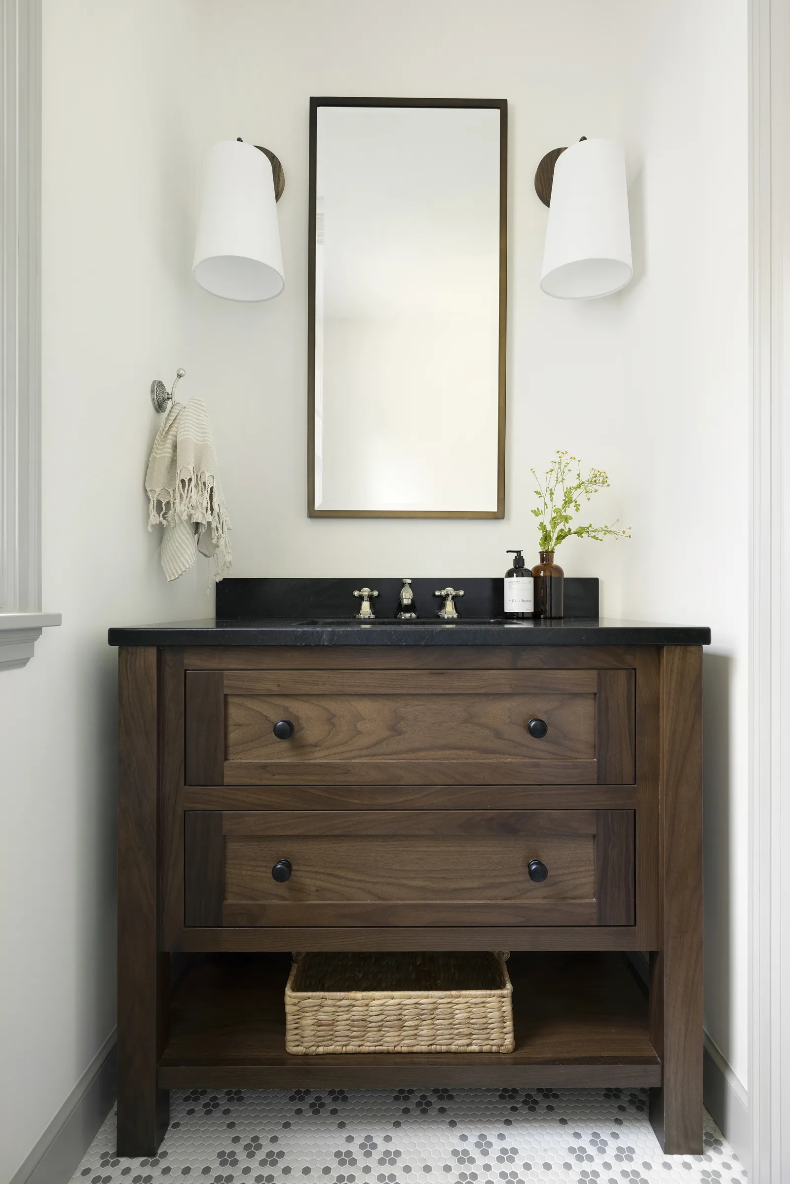 Walnut bathroom vanity with soapstone counter tops, gray and white mosaic floor tile.