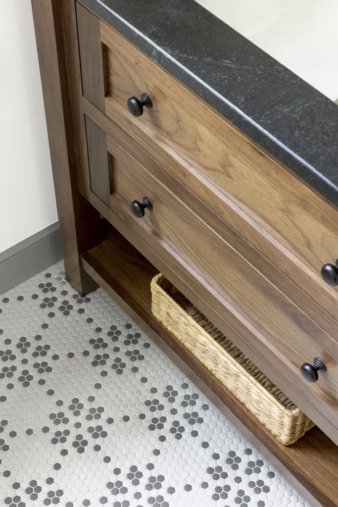 Gray and white mosaic bathroom tile, gray baseboard, walnut vanity.