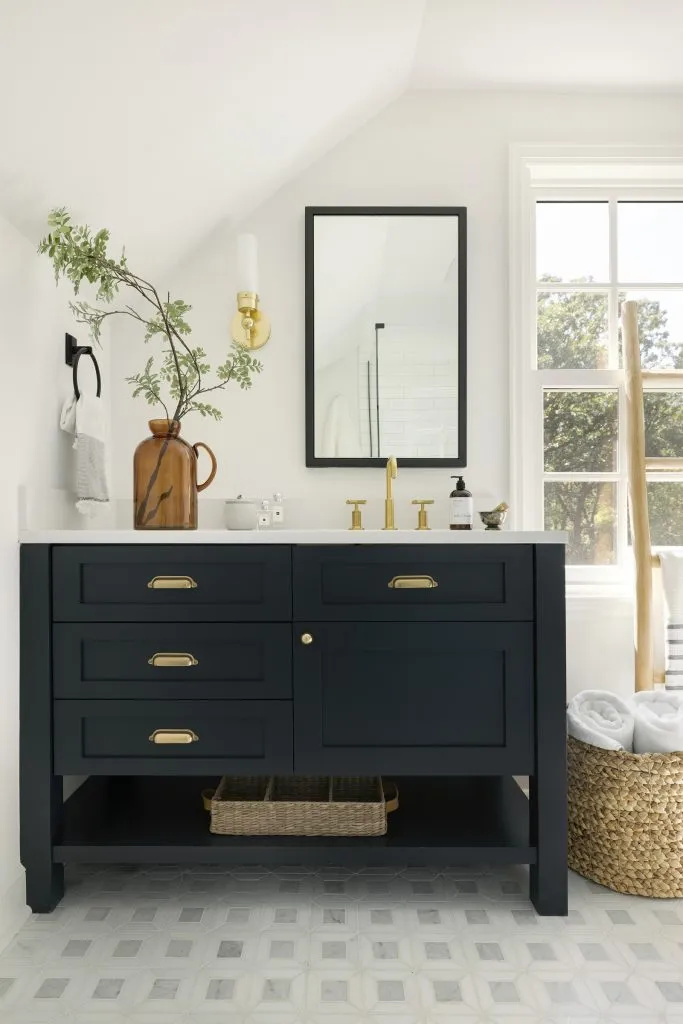 Black custom bathroom vanity, gold hardware and natural stone mosaic tile floor.