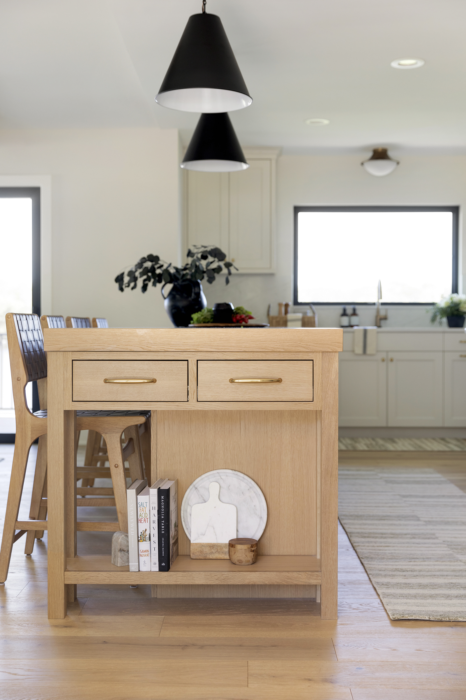 Natural white oak kitchen island with open storage and small drawer space.