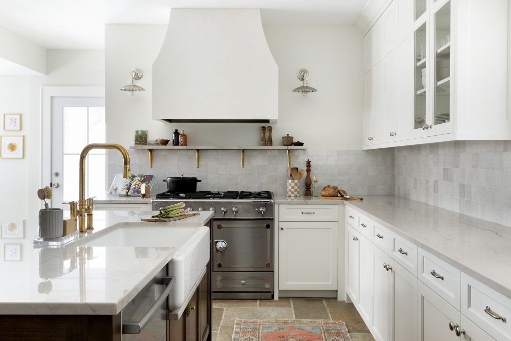 Modern French cafe inspired kitchen, white plaster hood, quatzite countertops, unlacquered brass, and natural limestone flooring.