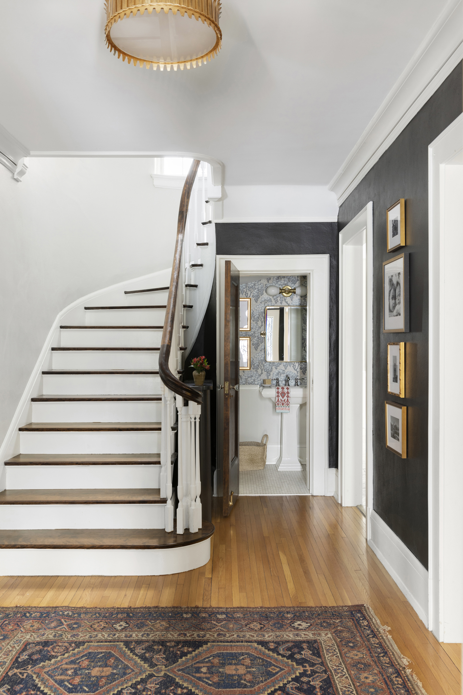 Twin Cities foyer renovation with curved staircase and dark walls.