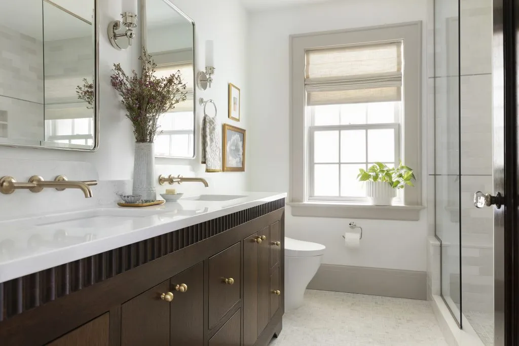 Stained oak custom beveled bathroom vanity, mixed metals and natural stone floor tile.