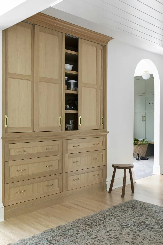 How to Refresh a 1920s Home, While Mixing Modern and Traditional Design Styles. Rift white oak built in pantry hutch, sliding storage doors and roll out drawers.