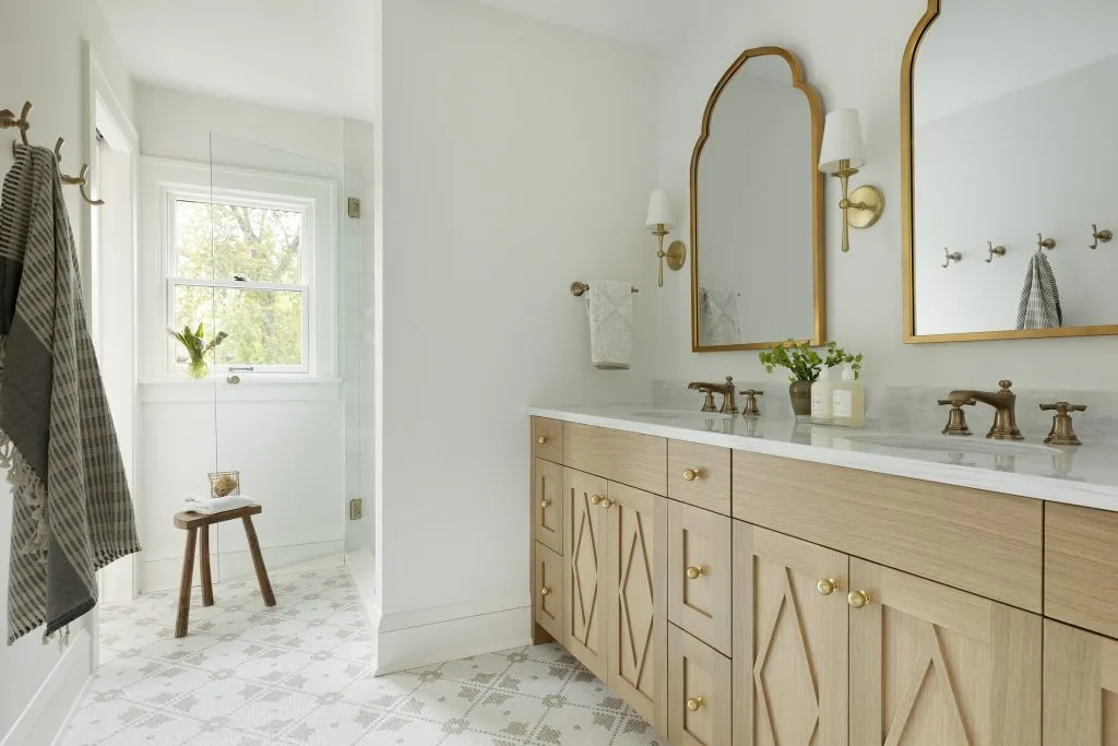 How to Refresh a 1920s Home, While Mixing Modern and Traditional Design Styles. Custom white oak bathroom vanity, aged brass hardware and traditional natural stone tile.