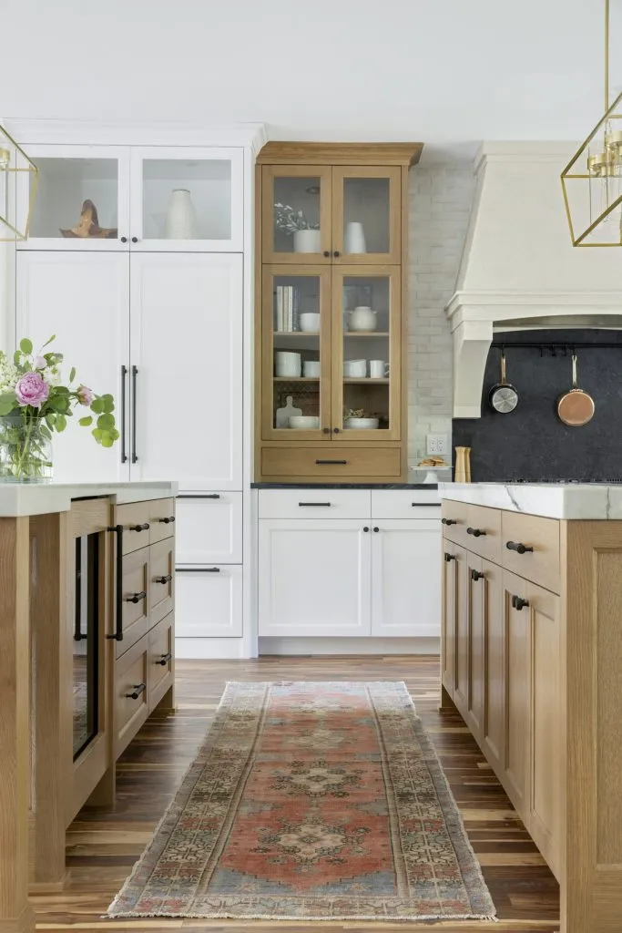 Dual white oak kitchen islands, quartzite and soapstone countertops, white painted accent cabinetry.